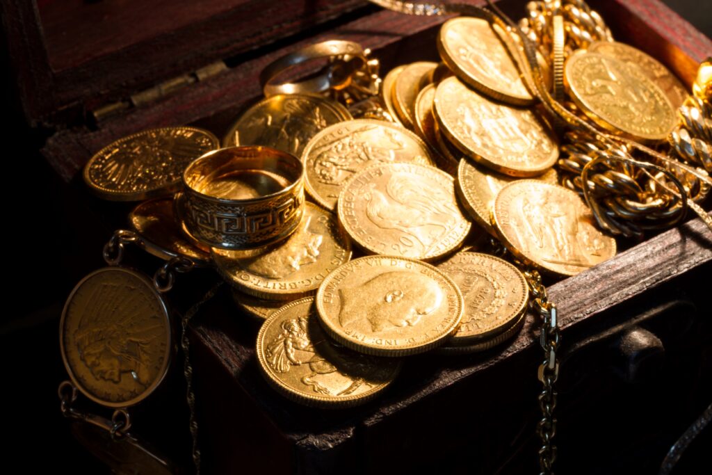 collection of gold coins and jewelry in a chest, reasons to own gold