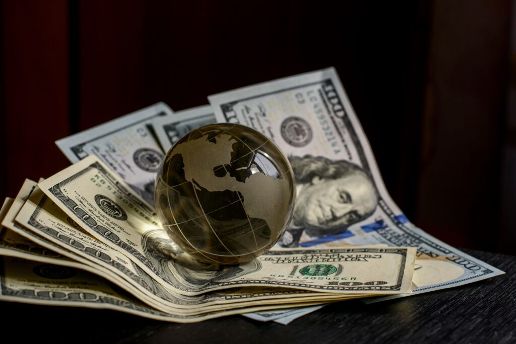 transparent globe sitting on 100 dollar us bills